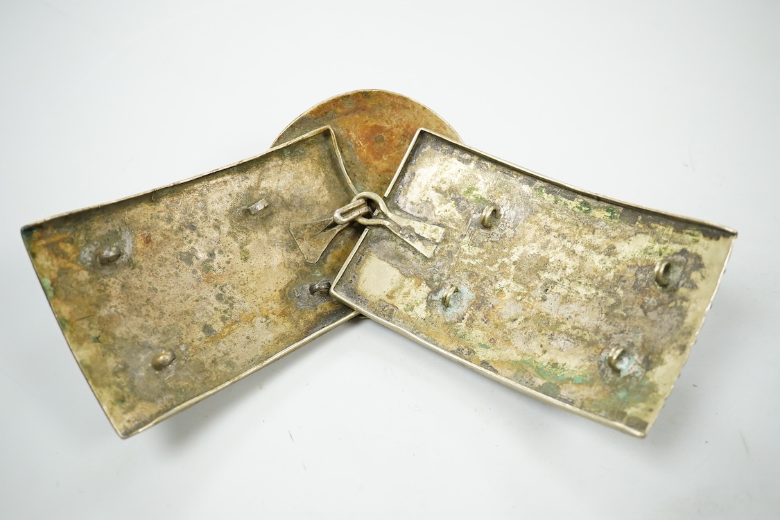 A niello work belt buckle, 21cm wide, an Arab white metal cloak brooch and a powder flask